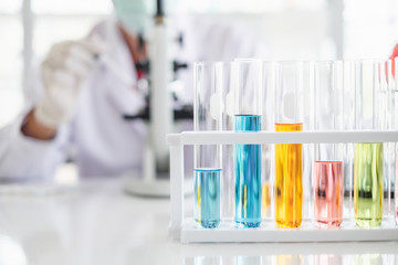 Wall Mural - a scientist hands working in laboratory with test tube microscope and solutions.