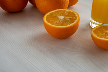 Wall Mural - an orange cut in half lies next to a bunch of oranges and a glass of juice