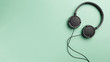 Black headphones on Mint background. Headphones on a pastel background. Flat lay top view copy space. Minimal style with colorful paper backdrop. Music concept. Neo Mint color of the year 2020