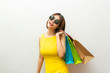 © jayzynism - Portrait of beautiful girl wearing dress and sunglasses holding shopping bags.