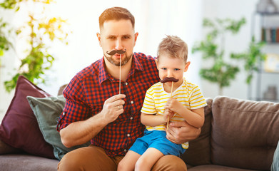  Father's day. Happy funny family son and dad with mustache .