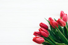 Beautiful Red Tulips On White Wooden Background In Light. Happy Mothers Day. Pink Tulips Border On White Wood  Border With Space For Text. Greeting Card Template. Hello Spring Concept