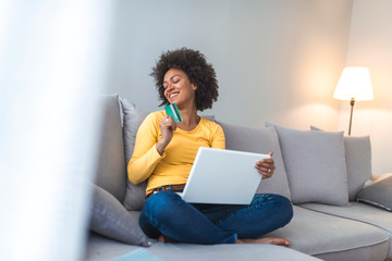 Wall Mural - Young woman holding credit card and using laptop computer. Online shopping concept