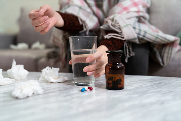 Wall Mural - hand holding water glass with pills on table