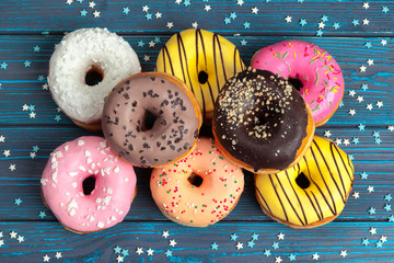 Poster - Colorful fresh donuts on dark blue wooden surface