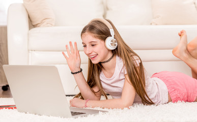 Cute teenager girl smiling at her laptop