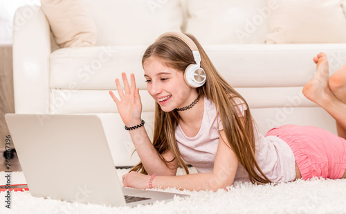 Cuadros en Lienzo Cute teenager girl smiling at her laptop