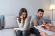 © Dragana Gordic - Angry couple speaking to a marriage counselor during therapy on a sofa in the living room of a house Sad marriage talking with female therapist, horizontal