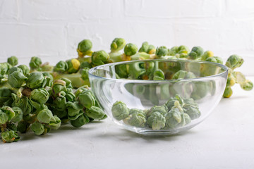 Wall Mural - Fresh raw organic brussels sprouts stalks on white background.