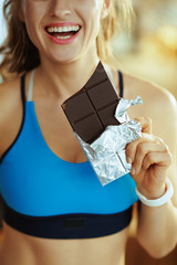 Wall Mural - Closeup on woman with chocolate bar in modern living room