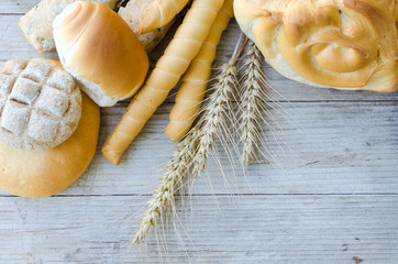 Assortment of baked bread on wooden table background