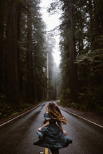Woman In Blue Dress On Road In Forest Redwoods