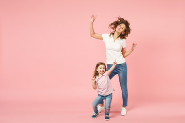 Wall Mural - Woman in light clothes have fun with cute child baby girl. Mother, little kid daughter isolated on pastel pink wall background, studio portrait. Mother's Day, love family, parenthood childhood concept