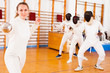 © JackF - Young female fencer practicing fencing technique in training room