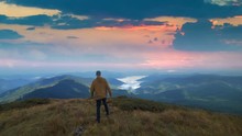 The Man Walking On The Mountain With On The Beautiful Sunset Background