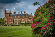 Stately home with red flower bush