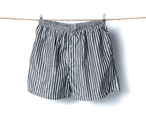 Men's boxer shorts hanging on rope isolated on white background