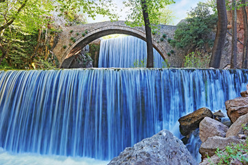 double waterfalls of Palaiokaria in Trikala Thessaly Greece - stony arched bridge between the two waterfalls - long exposure photography water