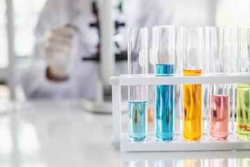 Wall Mural - a scientist hands working in laboratory with test tube microscope and solutions.