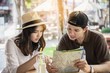Asian couple enjoy traveling sitting at coffee shop - happy young people on vacation concept