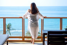 A Beautiful Asian Woman Standing And Enjoy Watching The Sea View At Balcony