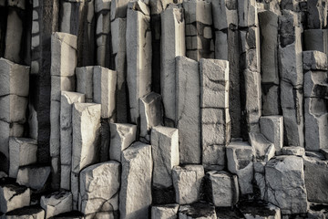 Column of basalt stone in The black sand beach of Reynisfjara and the mount Reynisfjall from the Dyrholaey promontory in the southern coast of Iceland.