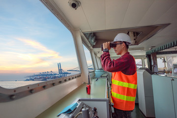 Wall Mural - duty officer in charge handle of the ship navigating to the port destination, keep watching navigation on the bridge of the ship vessel under voyage sailing to the sea