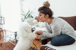 © likoper - Young woman playing with her dog at home