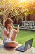 © astrosystem - Freelancer girl with smartphone, coffee / tea and laptop on a home porch.