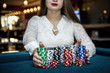 © RomanR - Female hands holding piles of casino chips on table