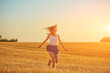 © astrosystem - Cute young woman jumping in a wheat field.