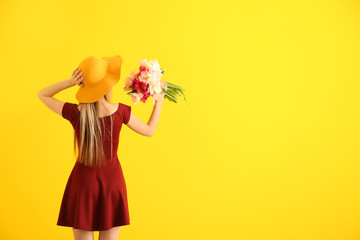 Poster - Young woman with bouquet of beautiful tulips on color background