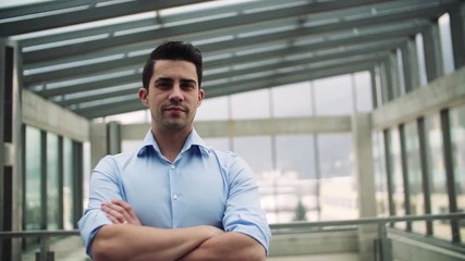 Wall Mural - Portrait of young businessman indoors in an office. Slow motion.