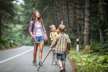Wall Mural - mother and her little sons at the nature .they walk by the old country road.