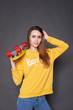 © Kiryl Lis - Portrait of positive young attractive girl wearing yellow blouse and blue jeans holding yellow skateboard.