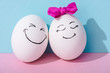 egg with bow and egg with happy face expression on blue and pink