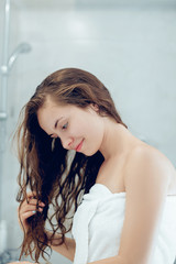 Canvas Print - Portrait Of Beautiful Young Female Model  in  Bath Applying Hair Oil. Closeup Of Sexy Woman In Towel Drying Wet Long Hair. Health And Beauty Concept. Protection moisturizing cream.