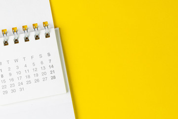 White clean calendar on solid yellow background with copy space, business, travel or project planning concept