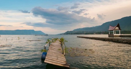 Wall Mural - Sunset Time lapse old wood jetty on lake Toba Samosir Island Sumatra Indonesia. Lake Toba is a huge volcanic caldera covered by water, home to Batak ethnic group