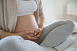 © goodluz - Closeup of pregnant woman belly