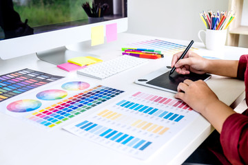 Poster - Image of female creative graphic designer working on color selection and drawing on graphics tablet at workplace