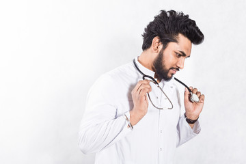 Poster - Handsome young doctor in a white coat with a stethoscope. Health care concept.