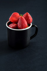 Fresh ripe strawberries in black metal cup