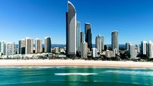 Stunning Aerial Shot The Iconic Skyscrapers And Beaches Of Surfers Paradise Gold Coast Queensland Australia. Drone Slides From Right To Left While Slowly Lowering To Just Above Water Level.