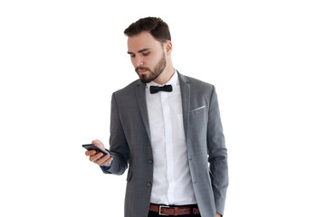 Wall Mural - Handsome businessman in suit. Young smiling business man in blue shirt reading sms, using smartphone