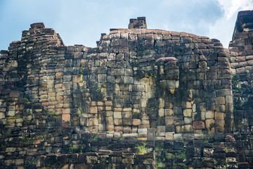 the buddha face of long reclining buddha building on the wall on the west side view of baphuon templ