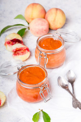 Wall Mural - Homemade peach jam with organic fruit. Sweet preserves on a light background