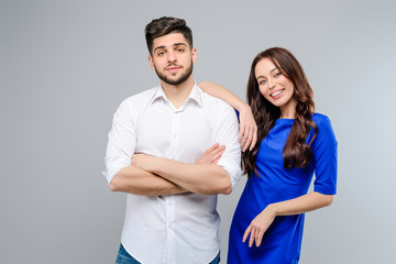 Wall Mural - Happy and smiling young couple of man and woman isolated over grey background