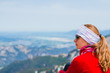 © marksn.media - Junge Frau sitzt auf einem Berg in den Allgäuer Alpen und schaut in die Ferne des Tals