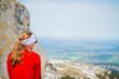 © marksn.media - Junge Frau sitzt auf einem Berg in den Allgäuer Alpen und schaut in die Ferne des Tals